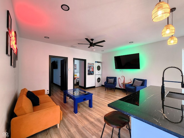 1046 Nelson Ave, Indianapolis, IN 46203 - living area with light wood-style floors, stacked washing maching and dryer, visible vents, and a ceiling fan