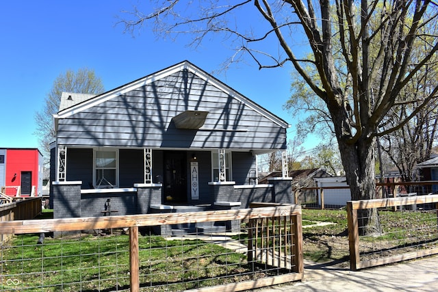 1046 Nelson Ave, Indianapolis, IN 46203 - view of front facade featuring covered porch and a fenced front yard