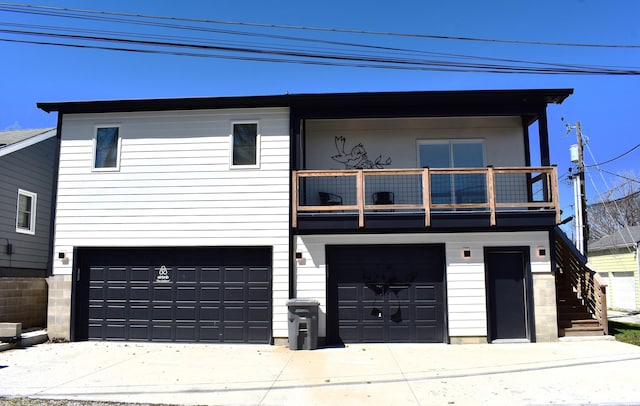 1046 Nelson Ave, Indianapolis, IN 46203 - view of front of property featuring concrete driveway, stairs, a balcony, and a garage