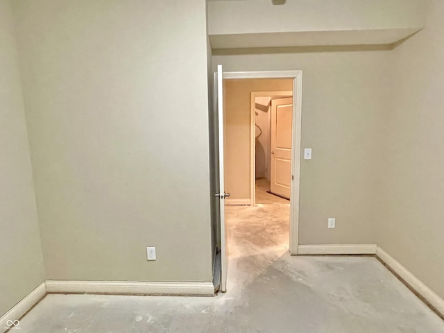 spare room featuring concrete flooring and baseboards