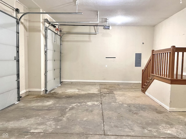 garage featuring a garage door opener, electric panel, and baseboards