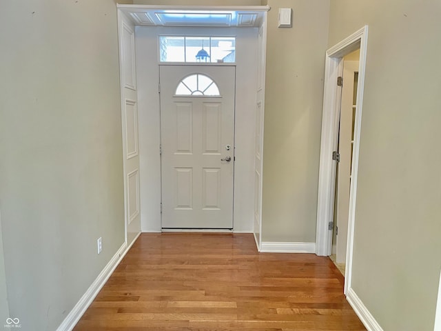 entryway with light wood finished floors and baseboards