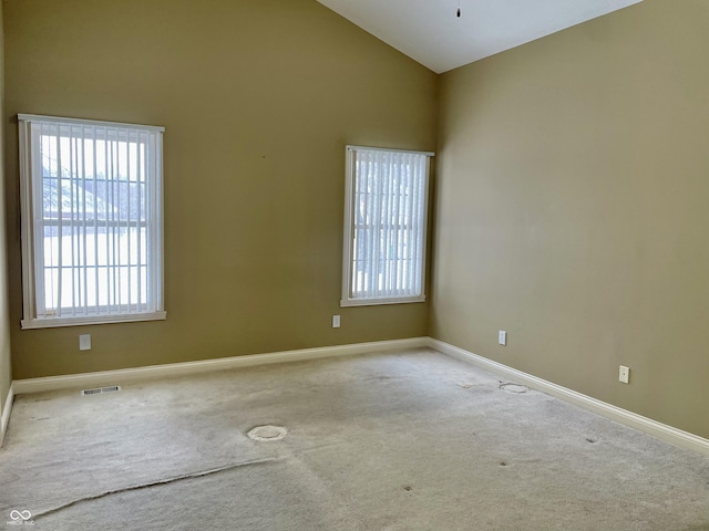 unfurnished room featuring high vaulted ceiling, carpet, visible vents, and baseboards