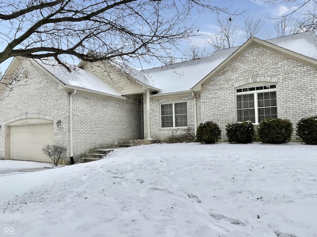 view of front of home with a garage and brick siding