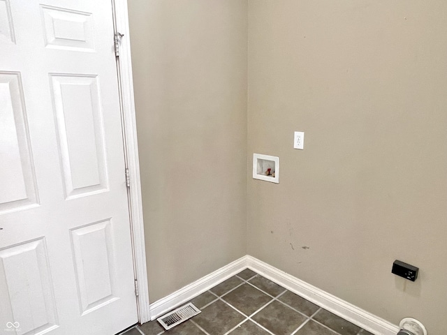 laundry room with hookup for a washing machine, laundry area, dark tile patterned flooring, visible vents, and baseboards