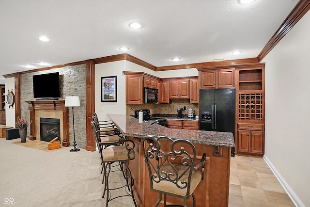 2110 Cheviot Ct, Greenwood, IN 46143 - kitchen featuring black appliances, crown molding, brown cabinetry, a breakfast bar area, and a peninsula