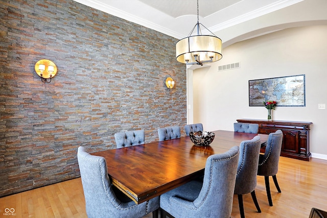 2110 Cheviot Ct, Greenwood, IN 46143 - dining space with arched walkways, light wood-style flooring, a chandelier, and ornamental molding