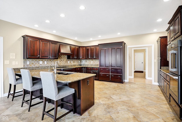 2110 Cheviot Ct, Greenwood, IN 46143 - kitchen with custom range hood, a sink, backsplash, a breakfast bar area, and recessed lighting