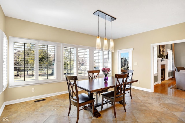 2110 Cheviot Ct, Greenwood, IN 46143 - dining area featuring light tile patterned floors, baseboards, and a glass covered fireplace