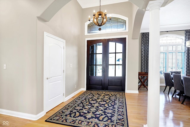 2110 Cheviot Ct, Greenwood, IN 46143 - foyer entrance with a chandelier, french doors, light wood-style flooring, arched walkways, and a towering ceiling