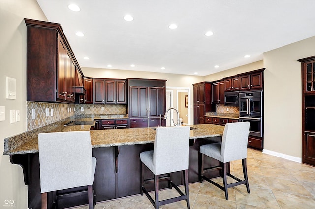 2110 Cheviot Ct, Greenwood, IN 46143 - kitchen with a sink, black appliances, a peninsula, recessed lighting, and tasteful backsplash
