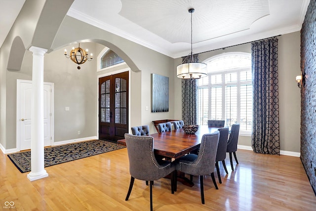 2110 Cheviot Ct, Greenwood, IN 46143 - dining room featuring arched walkways, light wood-style flooring, a chandelier, decorative columns, and french doors