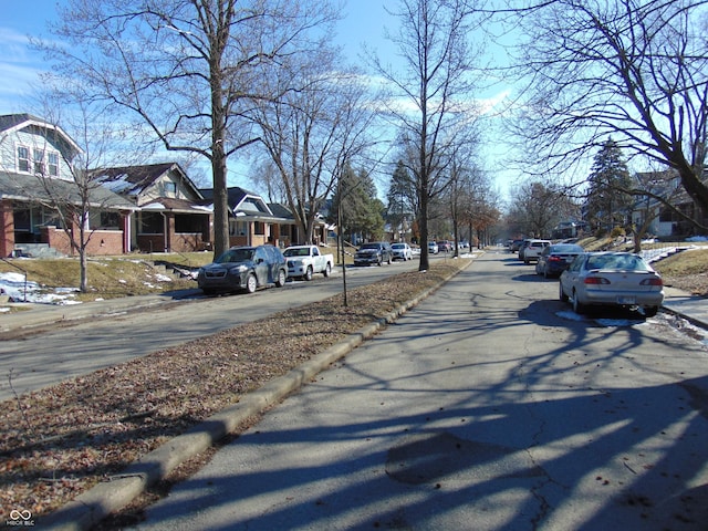 view of street featuring a residential view and curbs