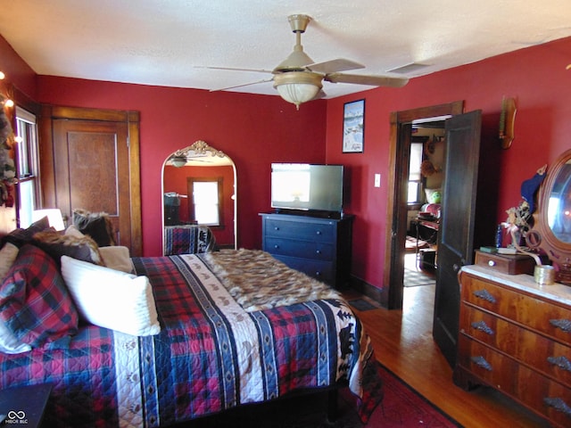 bedroom featuring dark wood-type flooring, visible vents, and ceiling fan