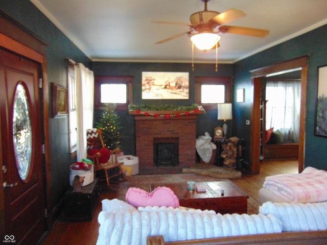 living room with crown molding, a fireplace, and wood finished floors