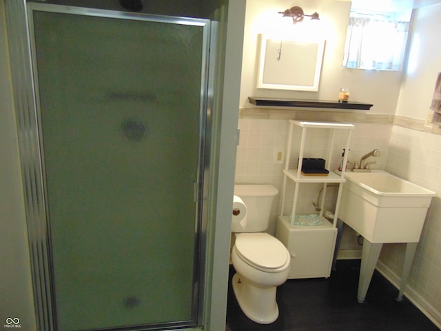 full bath featuring toilet, a wainscoted wall, a shower stall, and tile walls