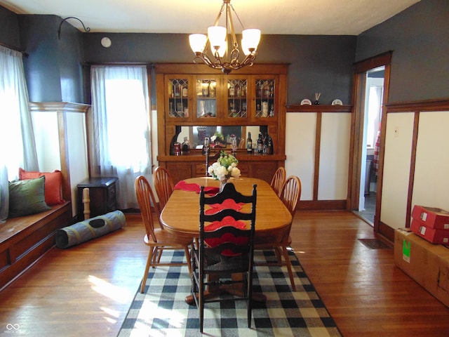 dining area with an inviting chandelier, baseboards, and wood finished floors