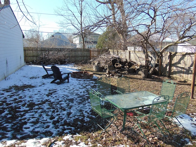 yard covered in snow featuring a fenced backyard and a fire pit