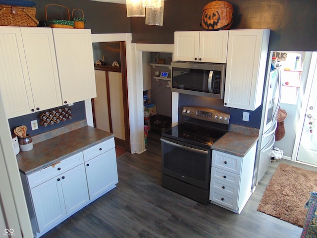 kitchen with appliances with stainless steel finishes, dark wood-style flooring, dark countertops, and white cabinetry