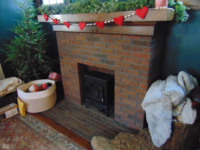 exterior details with a wood stove, a brick fireplace, and brick siding