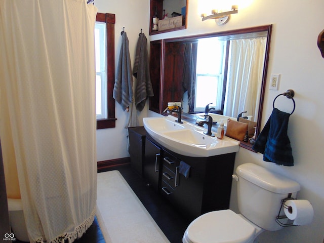 full bathroom with toilet, vanity, and baseboards