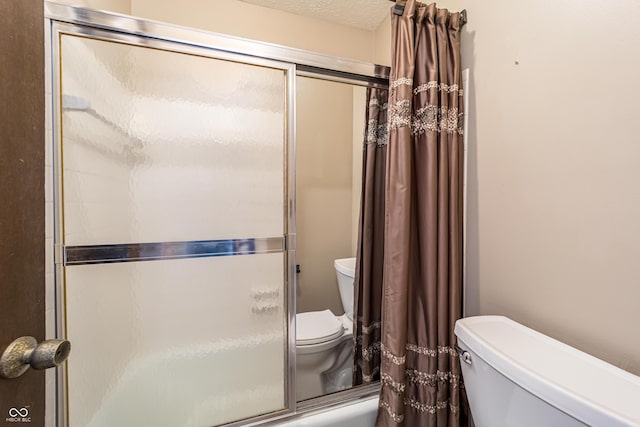 bathroom featuring curtained shower, toilet, and a textured ceiling