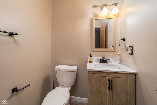 bathroom with vanity, toilet, and baseboards