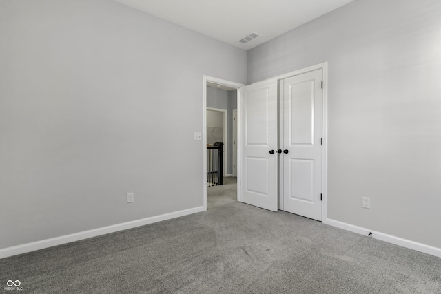 unfurnished bedroom with a closet, visible vents, baseboards, and carpet floors