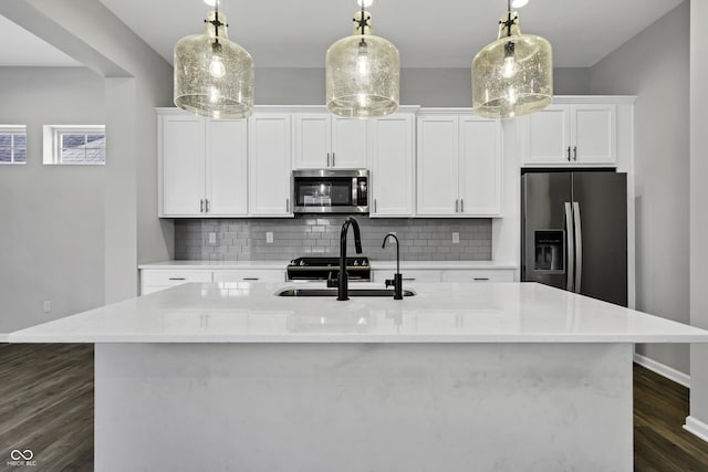 kitchen featuring white cabinets, backsplash, appliances with stainless steel finishes, and a sink