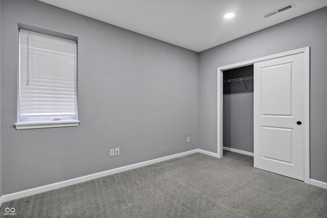 unfurnished bedroom with visible vents, recessed lighting, a closet, carpet flooring, and baseboards