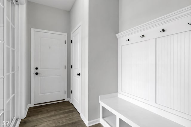 mudroom featuring dark wood finished floors and baseboards