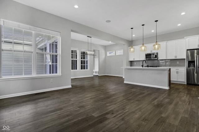 kitchen featuring dark wood-style flooring, light countertops, appliances with stainless steel finishes, white cabinetry, and tasteful backsplash