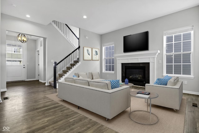 living room featuring recessed lighting, baseboards, dark wood-style floors, and stairs