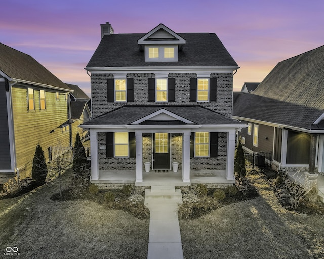 view of front of property with fence, a porch, a chimney, central air condition unit, and brick siding