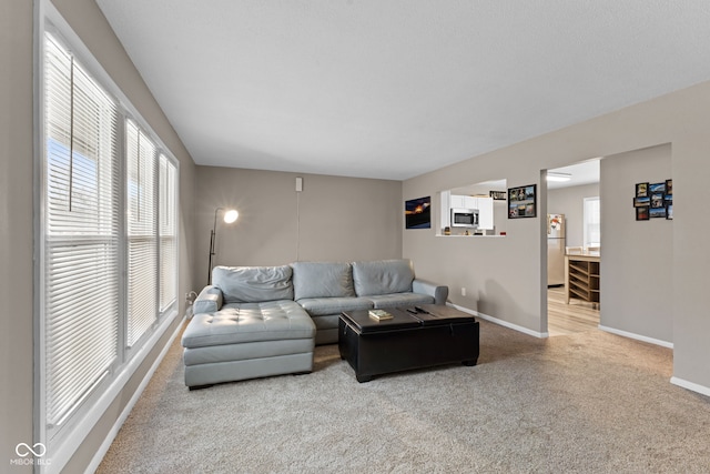 carpeted living area with baseboards