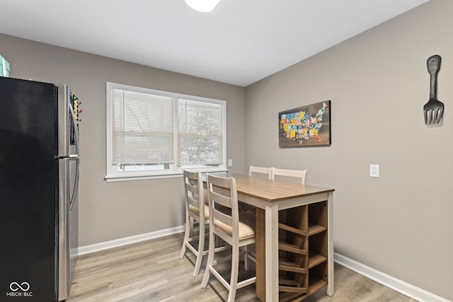 dining room with light wood-type flooring and baseboards