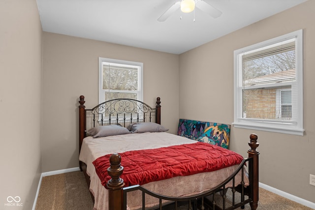 carpeted bedroom featuring multiple windows, baseboards, and a ceiling fan