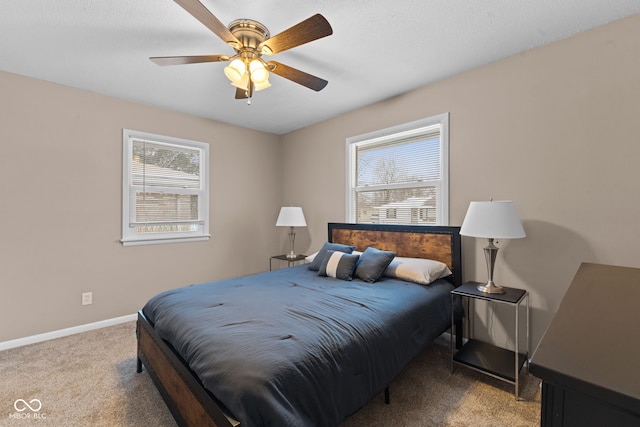 carpeted bedroom with multiple windows, baseboards, and a ceiling fan