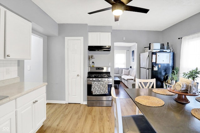 kitchen featuring light countertops, light wood-style flooring, appliances with stainless steel finishes, white cabinets, and under cabinet range hood