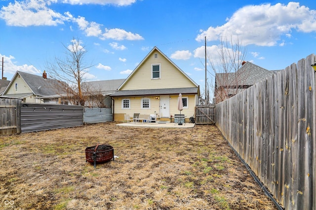 back of property with entry steps, an outdoor fire pit, a patio area, and a fenced backyard