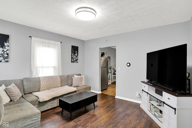 living area featuring dark wood-style floors, a textured ceiling, and baseboards