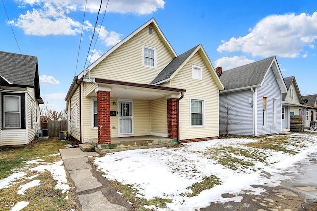 view of front of house with central AC, a porch, and fence