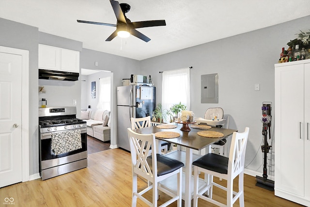 dining space with light wood-style floors, electric panel, ceiling fan, and baseboards