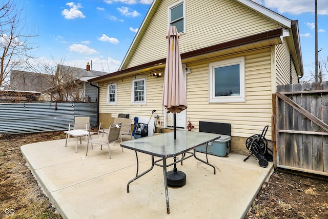 back of house featuring a patio area, fence, and outdoor dining space