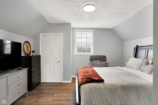 bedroom with vaulted ceiling, dark wood finished floors, a textured ceiling, and baseboards