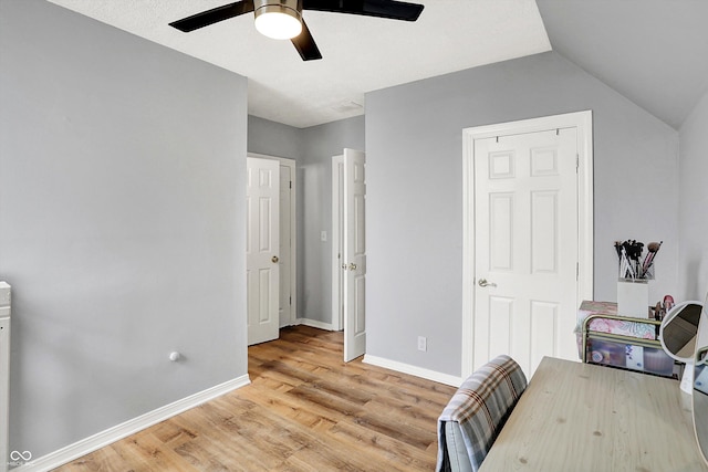 office with a ceiling fan, light wood-type flooring, vaulted ceiling, and baseboards