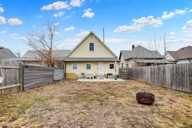 rear view of house featuring a fenced backyard, a patio, a fire pit, and central AC unit