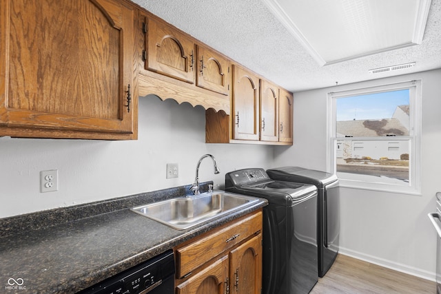 laundry room featuring a textured ceiling, laundry area, washing machine and clothes dryer, and a sink