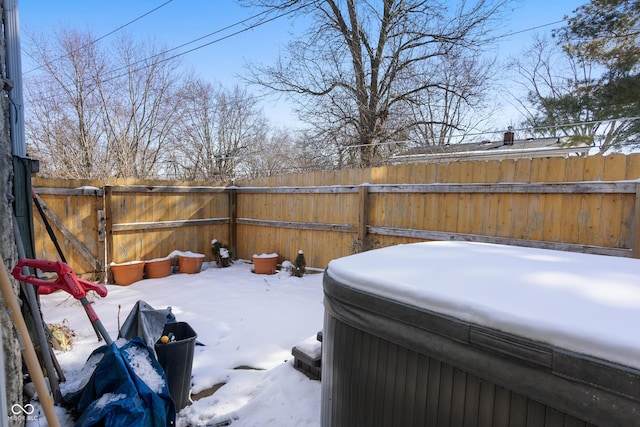 yard covered in snow featuring fence and a hot tub