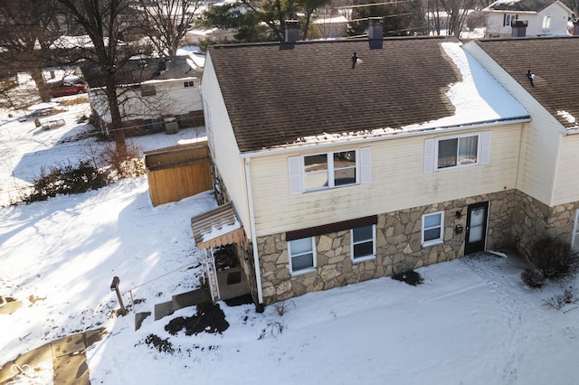 view of front of home with a shingled roof and a chimney